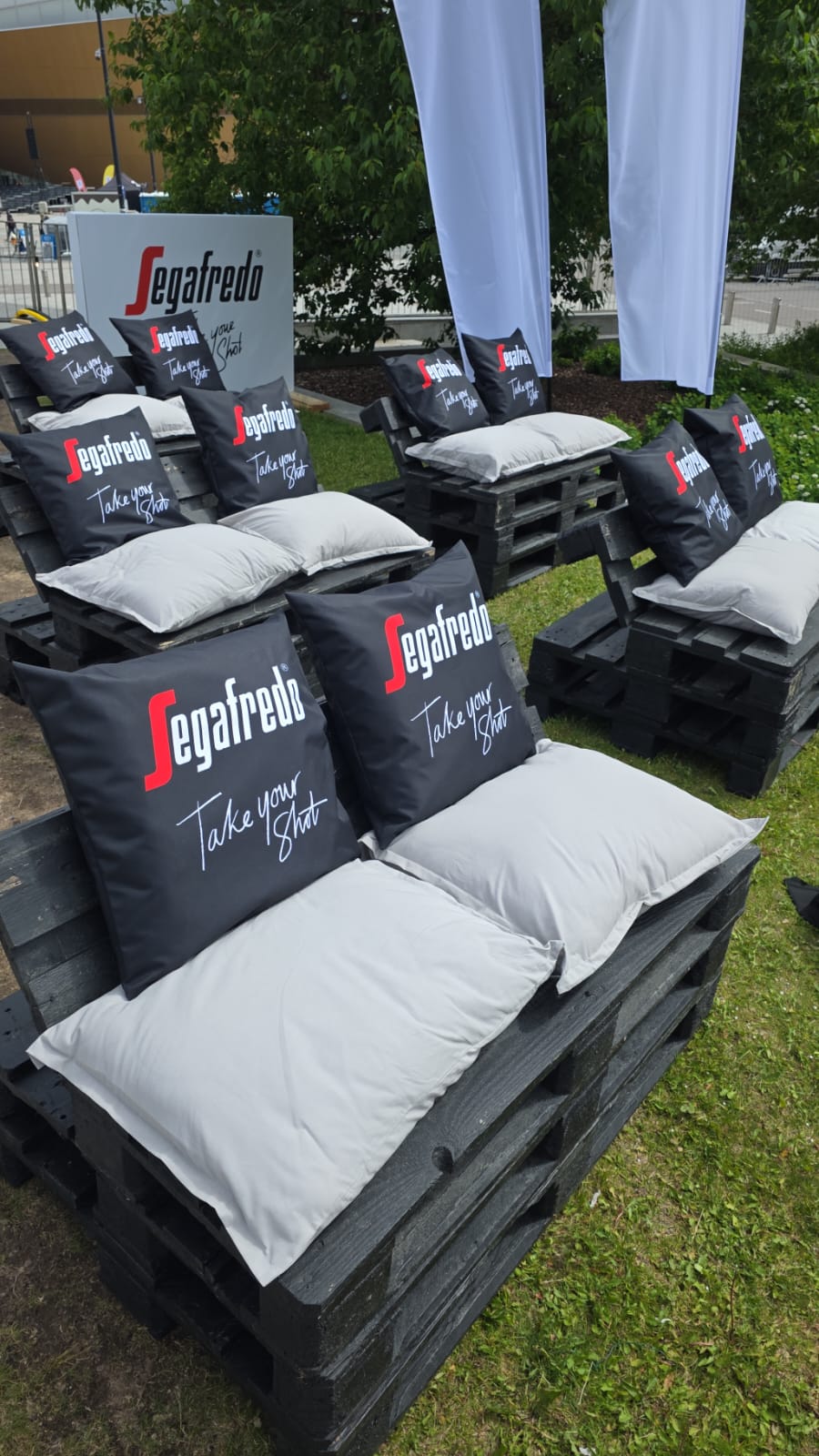Black-painted pallet sofas and branded Segafredo Take your Shot pillows